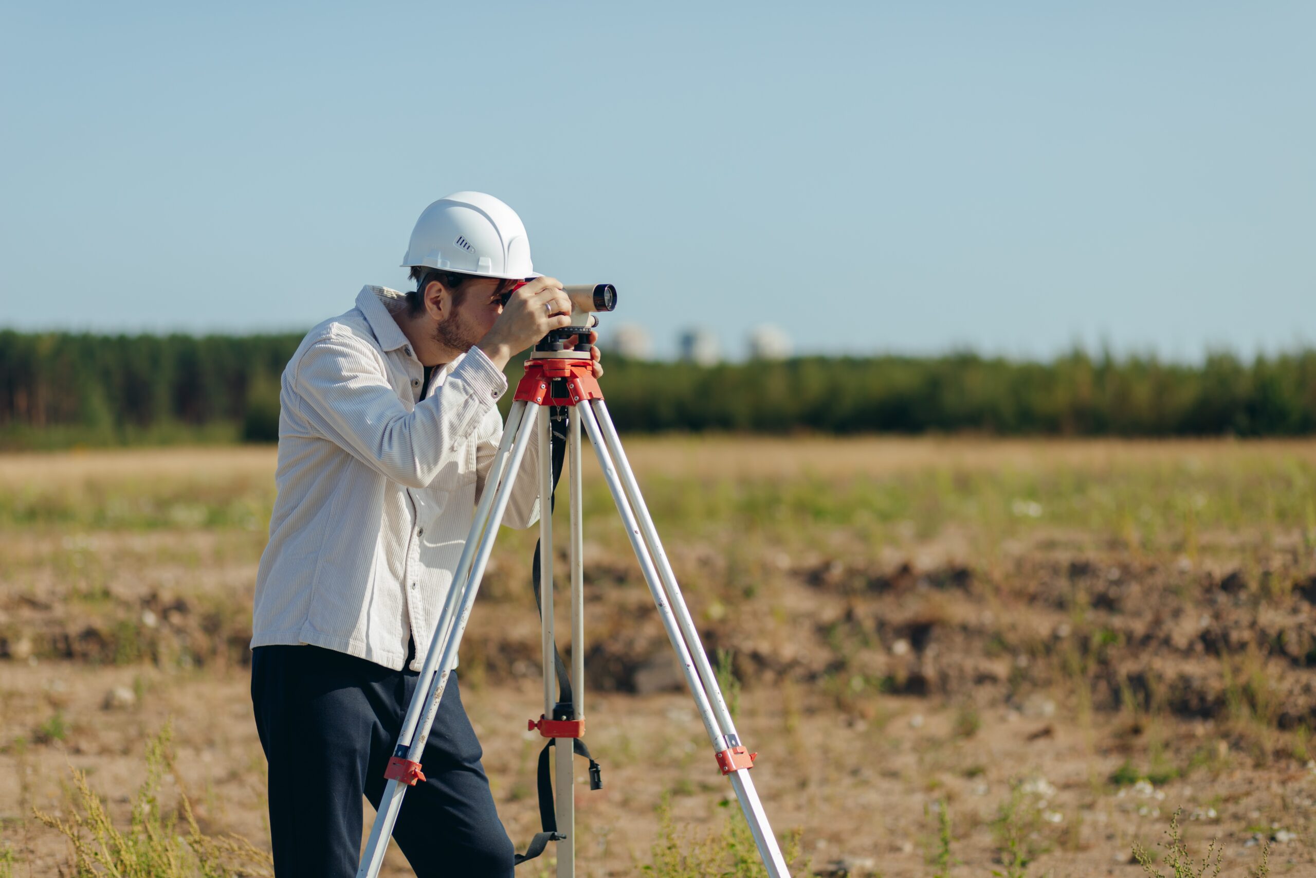 Survey engineer working with operating level survey cameras on construction site